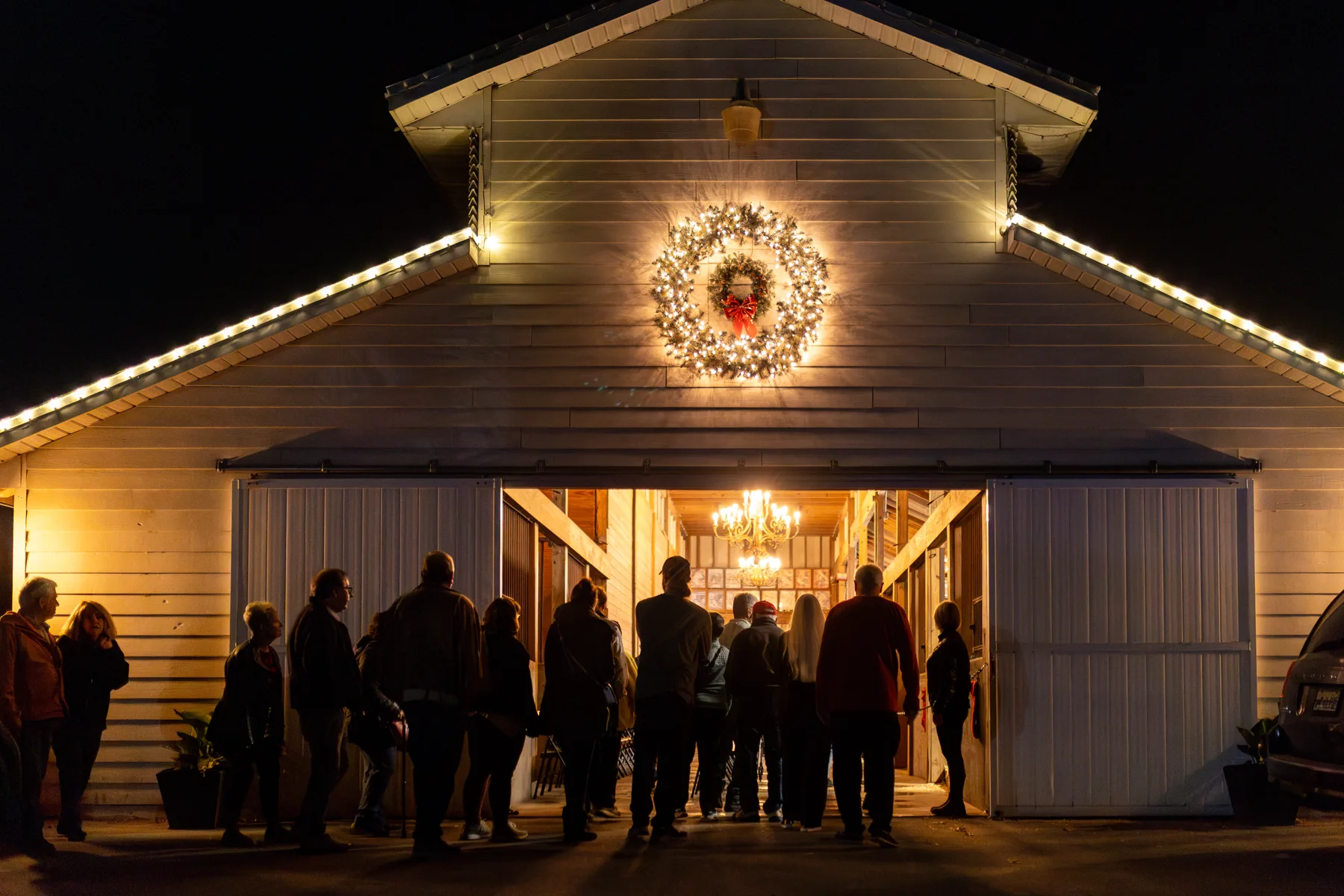 Guests entering a festively lit Grandview Clydesdales barn